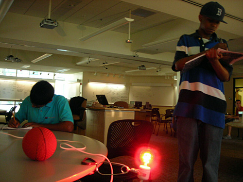 A red bulb illuminates a small ball.