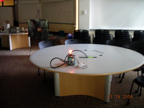 A lit bulb sits on a table.