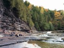 Students making measurements near a scenic river and steep cliffs.