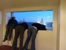 Photo of students observing the night sky through a high window.