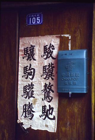 An image of a front door in Zhenjiang, central China.  A banner and a mailbox hang on the door.