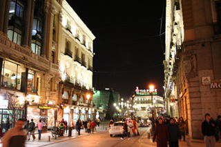 A row of posters advertising a film festival focused on the works of Pedro Almodovar, pictured in profile.