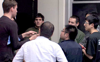 A group of eight students standing in a discussion circle.