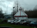 A parking lot with a circular coffee shop, a truck at the drive-thru window