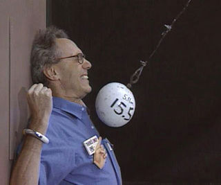 Photo of Prof. Lewin demonstrating the concept of Conservation of Mechanical Energy.