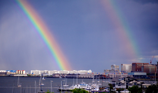 Photo of double rainbow over city harbor.