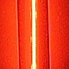 A bright white line of light sits vertically in front of an orange background.