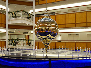 Photograph of a pendulum suspended from the ceiling over a circular base.