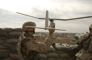 A photograph of an U.S. Army soldier launching a Raven unmanned aerial vehicle.