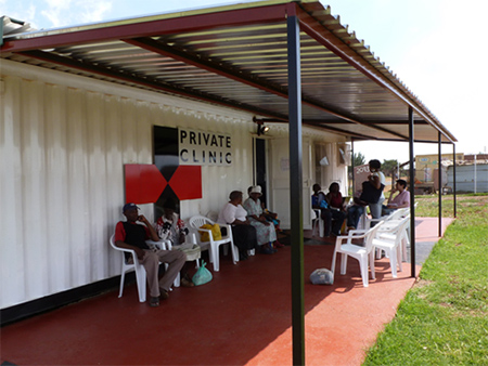 Patients sitting outside of a clinic.