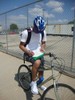 A student sits on a bicycle taking notes.