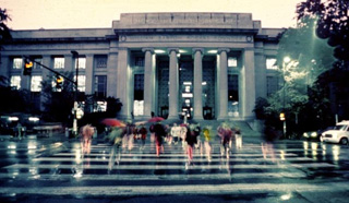 A picture of MIT students cossing Massachusetts Avenue in a rain storm.