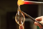 Photograph of the starter gathering glass onto a new pipe and preparing it for the next pumpkin.