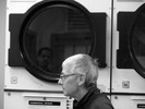 Photograph of a dad doing laundry. He finds himself doing laundry more often now that his young sons live with him.