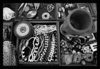 Photo of several trays of jewelry, pins and a wide variety of other small items.