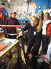 Photograph of Marissa Wozniak and Kat Apse, the two scuba instructors-in-training, hurrying around the shop, throwing their gear into bags and grabbing spare parts in case anyone needs to replace a piece of equipment at the site.