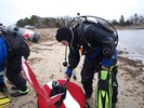 Photograph of assistant scuba instructor Dan Wagner carrying the heavy dive flag and the Easter eggs.