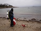 Photograph of Dan entering the water with the dive flag and Easter eggs.