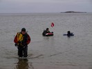 Photograph of Marissa, Kat, and Dan walking out of the water after depositing the eggs.