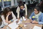 A girl is working on a worksheet with the help of a volunteer.